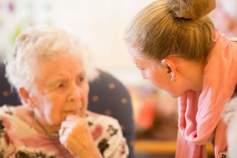 Junge Frau hört älterer Dame.