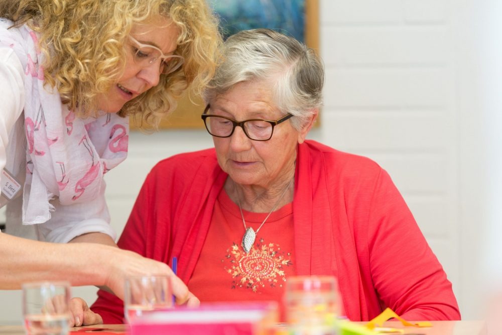 Hilfe beim Basteln mit Seniorin.